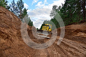 Dozer during clearing forest for construction new road . Yellow Bulldozer at forestry work Earth-moving equipment at road work,