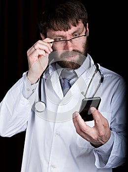 Dr. bearded man in a white medical robe, stethoscope on his neck, emotionally talking on phone