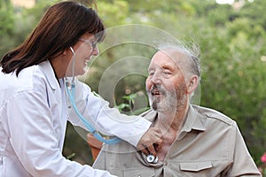 Dr with stethoscope checking senior patient.