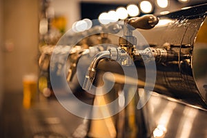 Draft beer taps in modern brewery, side view.