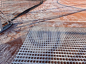 Drag mat or court sweeper is the tennis clay court covered with morning frost