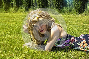 Drag queen lying on grass and looking