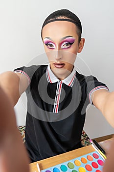 drag queen man taking a selfie in his transformation process and makeup