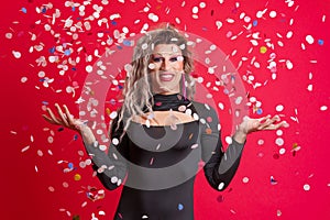 Drag queen person surrounded by confetti flying in the air