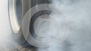 Drag racing car burning tire at startline in preparation for the race