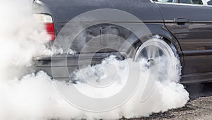 Drag racing car burns rubber off its tire