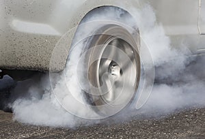 Drag racing car burns rubber off its tires