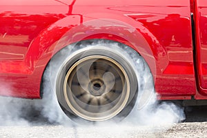 Drag racing car burns rubber off its tires