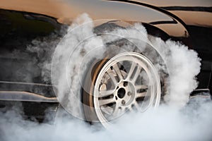 Drag racing car burns rubber off its tires in preparation for the race