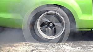 Drag racing car burns rubber off its tires in preparation for the race