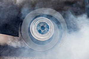 Drag racing car burns rubber off tire for the race