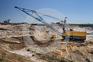 A dragline walking excavator works in a clay quarry