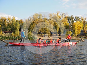 Dragon boat racing. Dragon boat participant practice paddling during sunset golden hour. Russia, Saratov - September 2019