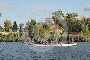 Dragon boat racing. Dragon boat participant practice paddling during sunset golden hour. Russia, Saratov - September 2019