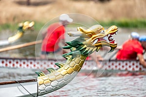 Dragon boat`s head with the race at the background