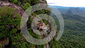 Dragon Crest mountain Krabi Thailand, a Young traveler sits on a rock that overhangs the abyss