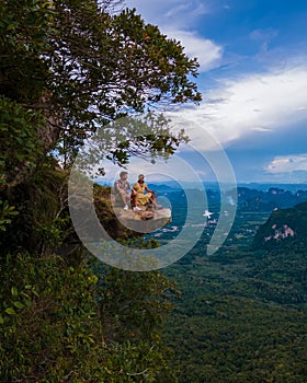 Dragon Crest mountain Krabi Thailand, a Young traveler sits on a rock that overhangs the abyss, with a beautiful