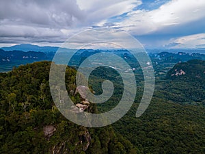 Dragon Crest mountain Krabi Thailand, a Young traveler sits on a rock that overhangs the abyss, with a beautiful