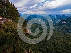 Dragon Crest mountain Krabi Thailand, a Young traveler sits on a rock that overhangs the abyss, with a beautiful