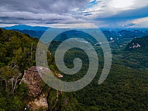 Dragon Crest mountain Krabi Thailand, a Young traveler sits on a rock that overhangs the abyss, with a beautiful