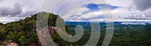 Dragon Crest mountain Krabi Thailand, a Young traveler sits on a rock that overhangs the abyss, with a beautiful