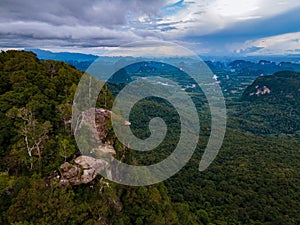 Dragon Crest mountain Krabi Thailand, a Young traveler sits on a rock that overhangs the abyss, with a beautiful