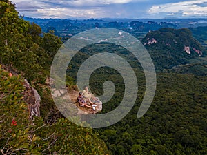 Dragon Crest mountain Krabi Thailand, a Young traveler sits on a rock that overhangs the abyss, with a beautiful