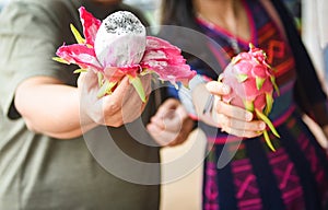 Dragon fruit in hand man and woman at the fruit market - Fresh Pitaya