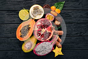 Dragon fruit, papaya, kumquat, hranadylla, avocado, passion fruit. Tropical Fruits. On a wooden background.