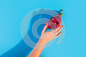 Dragon fruit or pitaya hand touched on isolated blue background as package design element