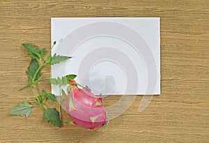 Dragon fruit, purple, white paper, leaves, wood background,