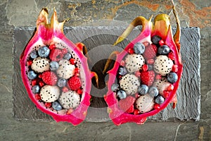 Dragon fruit salads with berries over slate photo