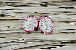 Dragon fruit slices, cut, half on palm leaves. Organic, still life photography concept.