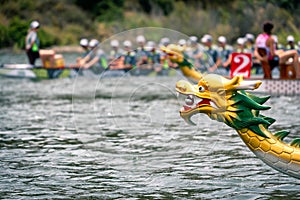 Dragon`s head with dragon boat racing team at the back