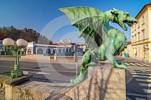Dragon statue on Dragon bridge and Ljubljana castle and Saint Nicholas Cathedral in the background, Ljubljana, Slovenia
