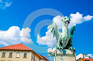 Dragon statue from Ljubljana, Captial city of Slovenia in eastern Europe. Nice blue sky with white clouds, red roofs background.