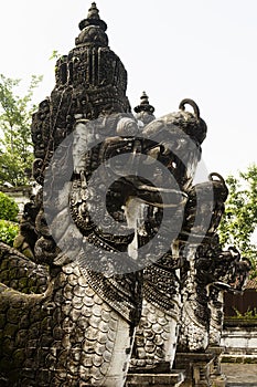 Dragon statues carved of stone decorate of traditional balinese sacred temple of Lempuyang on Bali, vertical, fragment. Majestic.
