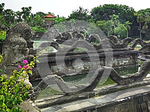 Dragons decorations at the edge of a water feature in front of the balinese hindu temple on Bali island in Indonesia