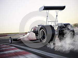 Dragster racing down the track with burnout photo