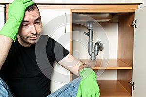 Drain Problems, blockage plumbing kitchen sink pipe unclog male man sit tired