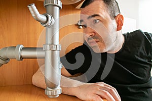 Drain Problems, blockage plumbing kitchen sink pipe unclog plunger man hand hold