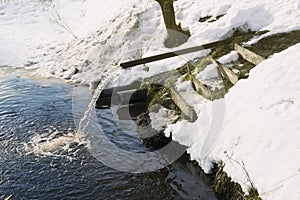 Drain in the river, thaw, snowbreak, drainage