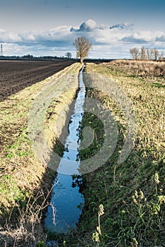 Drainage channel running alongside a ploughed field photo