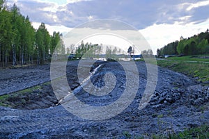 Drainage ditch in the peat extraction site. Drainage and destruction of peat bogs in finland