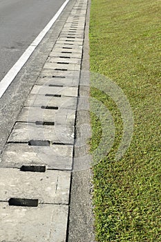 Drainage ditch on the side of the road and green grass