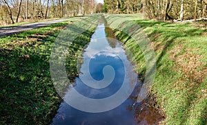 Drainage ditch to drain the moor area, with embankments with grass