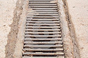 Drainage channel with a grate made of iron rods .