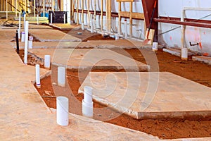 Drainage pvc pipe concrete floor reveals exposed endings for future lavatory restroom plumbing