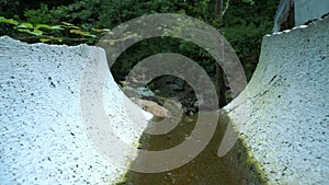 Drainage system in the forest. Water flowing through the channel. Forest and park drainage in the Alps. Drainage system