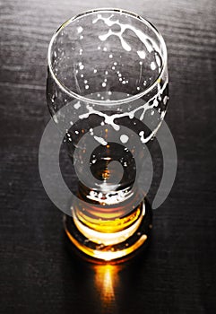 Drained glass of lager beer on table